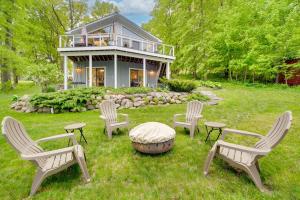 un grupo de sillas sentadas en el césped frente a una casa en Wisconsin Vacation Rental with Fire Pit on Long Lake, 