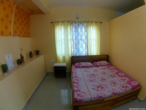 1 dormitorio con cama con sábanas rosas y ventana en Mountain View Homestay Kalimpong, en Kalimpong