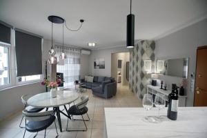 uma cozinha e sala de estar com mesa e cadeiras em Ioanna's Luxury Two Bedroom Apartment em Nafplio