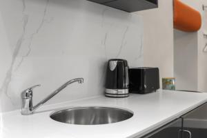 a kitchen counter with a sink and two toasters at Modern Studio Flat in London
