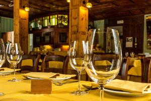 uma mesa com copos de vinho numa mesa num restaurante em Albergo Monte Cervino em Champoluc