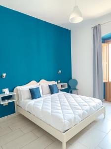 a bedroom with a blue wall and a bed at La Residenza B&B in Giba
