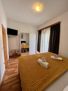 Apartments and pansion M&R في توراني: غرفة نوم عليها سرير وفوط