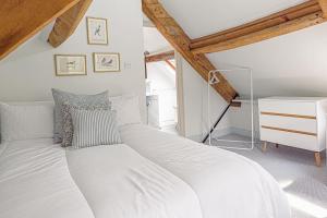 a large white bed in a room with a desk at Mill House Cottage - Star Stay on The Cotswold Way in Harescombe
