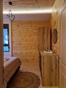 a bedroom with a bed and a wooden wall at OLEA COTTAGE in Ulcinj +37 photos