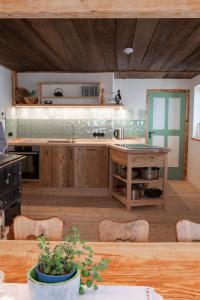 una cocina con armarios de madera y una mesa con sillas. en Hasenalm en Schliersee