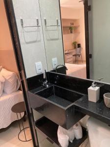 a bathroom with a black sink and a mirror at Flats Condomínio Park Ville by CentoEdez in Brasilia