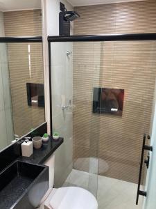 a bathroom with a glass shower with a toilet at Flats Condomínio Park Ville by CentoEdez in Brasília