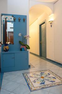 a hallway with a blue wall and a door and a rug at Oasi in Maiori