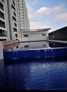 einem Wasserpool vor zwei hohen Gebäuden in der Unterkunft Aqilla Homestay in Kuala Selangor