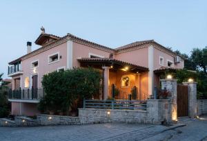 uma grande casa cor-de-rosa com luzes acesas em Villa Zante em Zakynthos Town