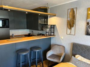 a kitchen with two bar stools and a counter top at Apartment Studio Green line in Bannewitz