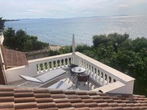 balcón con mesa, sillas y vistas al océano en Bed&Breakfast Vanni, en Privlaka