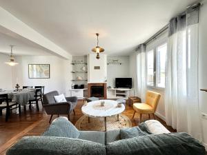 uma sala de estar com um sofá e uma mesa em Maison de pêcheur - À 200m de la plage em Ploemeur