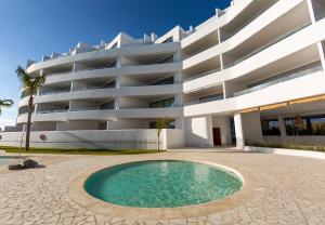 a building with a swimming pool in front of a building at Homity Exclusive Playa Granada Beach & Golf - Mar de Astrid in Motril