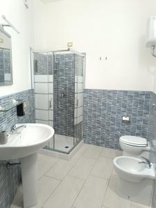 uma casa de banho com 2 lavatórios, um chuveiro e um WC. em La Residenza B&B em Giba