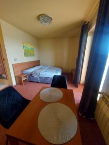 um quarto com uma cama e uma mesa com um chapéu em Apartmán - Tatragolf Veľká Lomnica em Veľká Lomnica