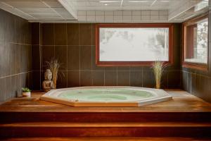 a jacuzzi tub in a bathroom with a window at Dormio Resort Les Portes du Mont Blanc in Vallorcine +13 photos