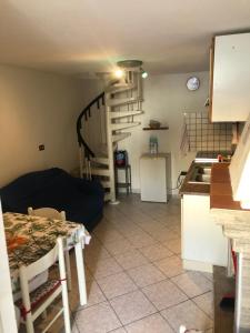 ein Wohnzimmer mit einem Tisch und einer Wendeltreppe in der Unterkunft Cannarsa in San Giacomo degli Schiavoni