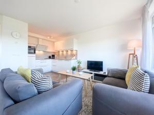 een woonkamer met twee blauwe banken en een tafel bij Vakantieappartement Westkapelle WE07 in Westkapelle