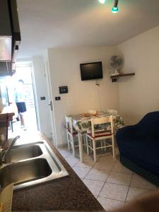 eine Küche mit einem Tisch und einem TV an der Wand in der Unterkunft Cannarsa in San Giacomo degli Schiavoni