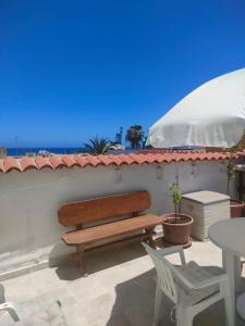 un banc en bois assis sur un mur avec une table dans l'établissement Casa Alba 2, à Puerto del Rosario