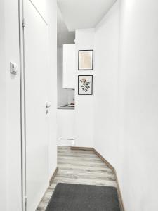 a hallway with white walls and a black rug at Beautiful Central Apartment Helsinki in Helsinki