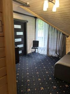 Cette chambre comprend un lit, une fenêtre et une chaise. dans l'établissement Chalet Carpat Dream, à Lac Synevyr