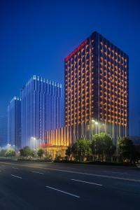 a tall building with lights on the side of it at Wanda Realm Bengbu in Bengbu