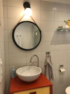 een badkamer met een wastafel en een spiegel bij Cozy cottage by the sea south of Varberg in TrÃ¤slÃ¶vslÃ¤ge