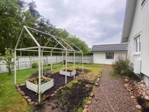 un jardín con invernadero en un patio en Cozy cottage by the sea south of Varberg en TrÃ¤slÃ¶vslÃ¤ge