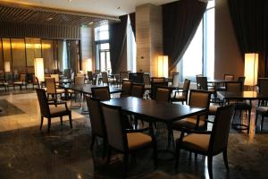 a dining room with tables and chairs and windows at Wanda Realm Bengbu in Bengbu