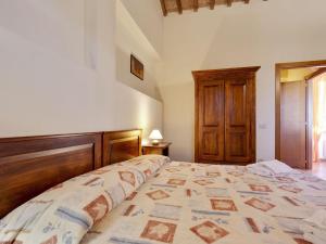 een slaapkamer met een groot bed met een houten hoofdeinde bij Comfortable Mansion in Siena with Swimming Pool in Siena