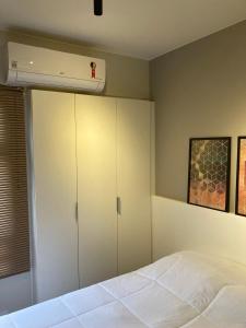 um quarto com armários brancos e uma cama branca em Flat Condomínio Garden Park by CentoEdez em Brasília