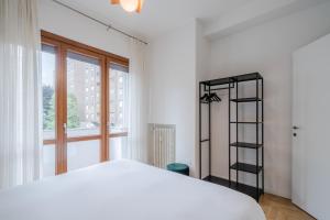 1 dormitorio con cama blanca y estante negro en RELSTAY - CityLife - 2BR en Milán