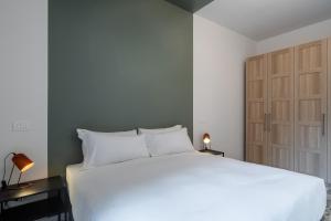 1 dormitorio con 1 cama blanca grande y armario en RELSTAY - CityLife - 2BR en Milán