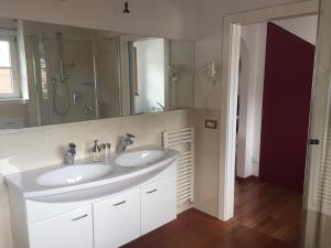 uma casa de banho com 2 lavatórios e um espelho grande em Apartment Cesa Collina Superior em Ortisei