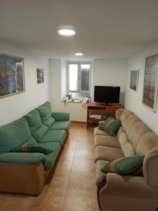 - un salon avec deux canapés et une télévision dans l'établissement Casa en Puerto de Bares, à Bares