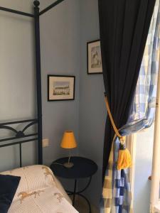 1 dormitorio con cama, mesa y ventana en La Maison des Roses en Mareuil-sur-Lay