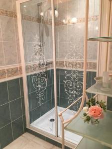 y baño con ducha y puerta de cristal. en La Maison des Roses en Mareuil-sur-Lay