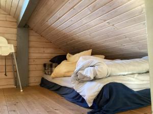 a bed in a room with a wooden ceiling at Holiday home Hovborg XII in Hovborg