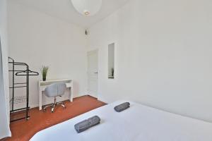 a white bedroom with a bed and a desk and a chair at Au Roi RENE - AC CLIM - WIFI in Avignon