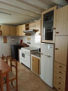 a kitchen with a white refrigerator and a table at Casa en Puerto de Bares in Bares