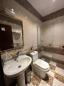 een badkamer met een wit toilet en een wastafel bij وجهة التميز 2 in Jeddah