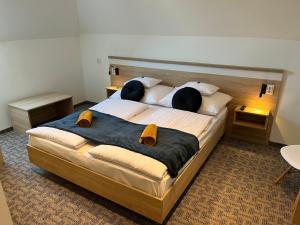 a bedroom with a large bed with two pillows at GreenWood Vendégház in Siófok