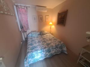 um pequeno quarto com uma cama com um edredão azul em Splendida mansarda fronte spiaggia la Boheme by PortofinoVacanze em Santa Margherita Ligure