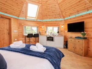 a bedroom with a large bed in a wooden cabin at Dragonfly Retreat in Pentney