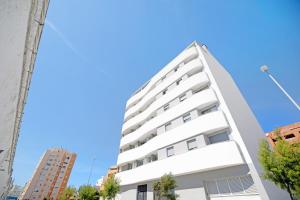 un edificio de apartamentos blanco contra un cielo azul en La Gaditana, en Cádiz