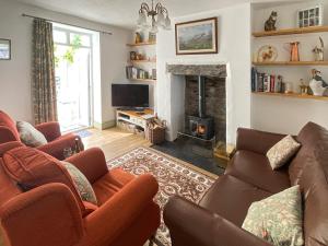 sala de estar con sofá y chimenea en Llys Deulyn en Trefriw