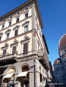 un edificio blanco alto con ventanas en una calle en Palazzo Gamba Apartments al Duomo, en Florencia